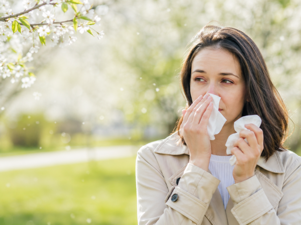 υναίκα με συμπτώματα αλλεργικής ρινίτιδας την άνοιξη σε εξωτερικό χώρο